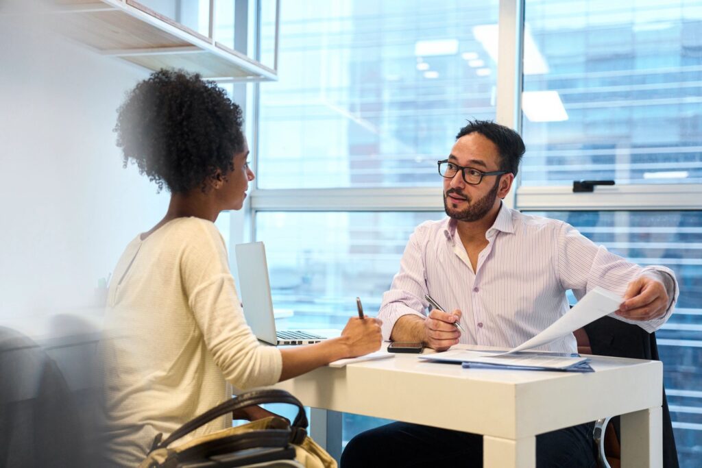 Adult male financial advisor discussing with female customer at office