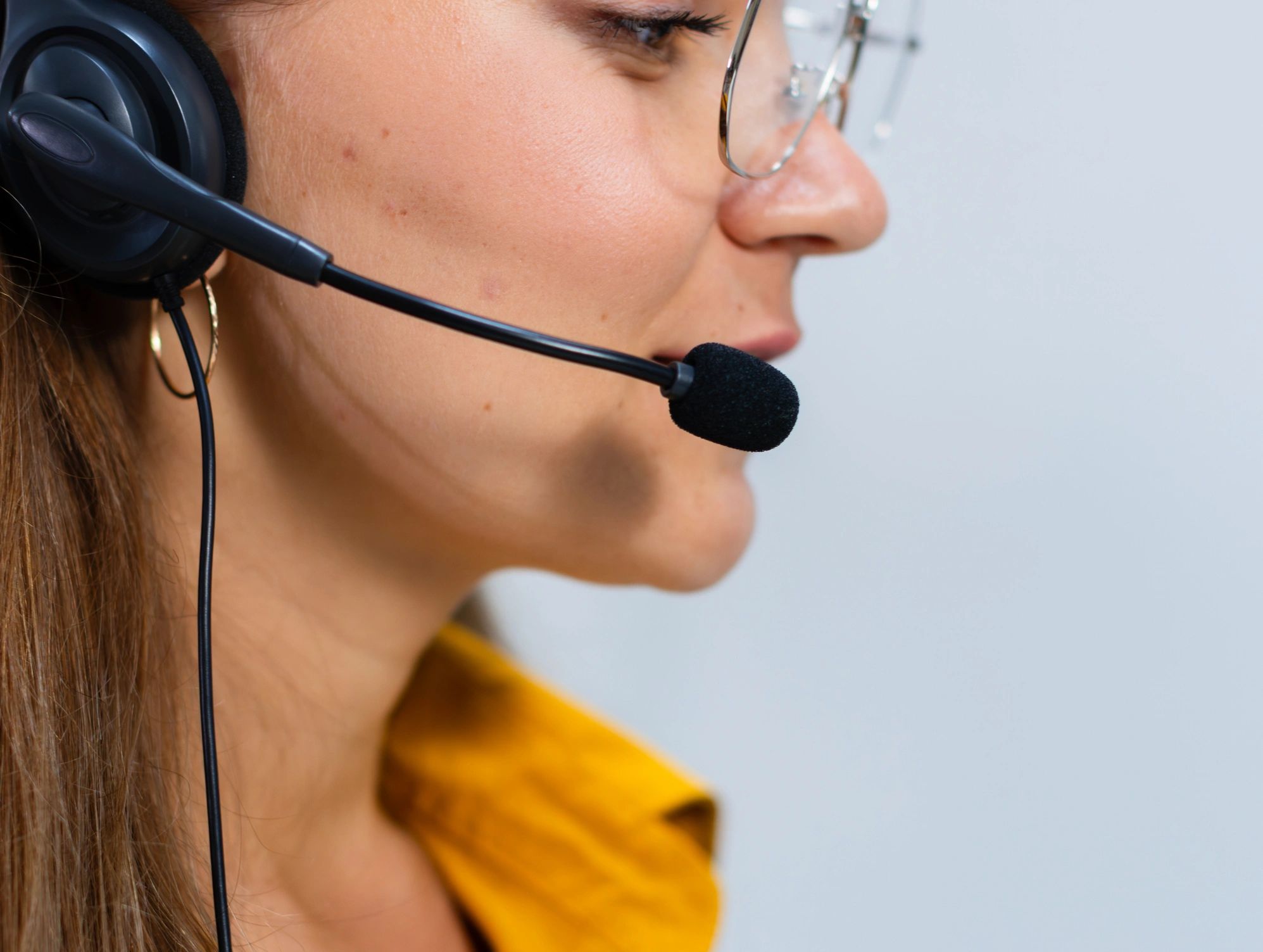 Support specialist answering a call at a computer, representing 24/7 confidential help